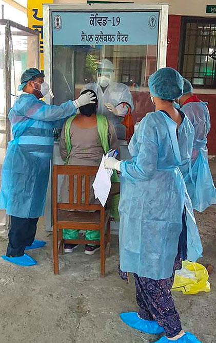 पटियाला के मॉडल टाउन में एक सरकारी डिस्पेंसरी में कोविड-19 टेस्ट के लिए नर्सों और आशा कार्यकर्ताओं के स्वाब नमूने एकत्र करते स्वास्थ्यकर्मी
