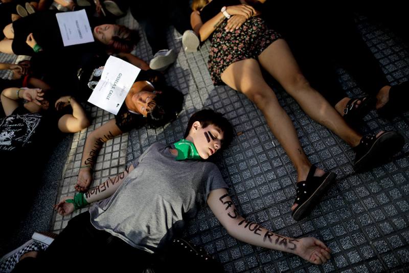 अर्जेंटीना के ब्यूनस आयर्स में लिंग आधारित हिंसा के विरोध के दौरान पीड़ितों के रूप में प्रदर्शन करते हुए महिलाएं।