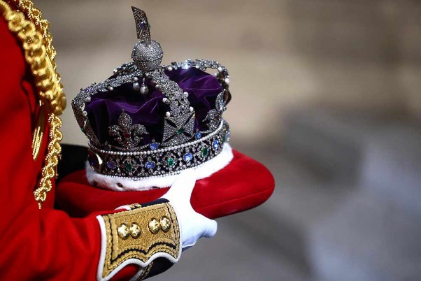 लंदन में संसद के आधिकारिक उद्घाटन समारोह में ले जाते ब्रिटेन की महारानी एलिजाबेथ द्वितीय का ताज