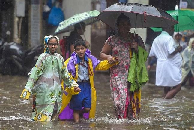 मुंबई में बारिश के दौरान के स्कूल जाते बच्चे