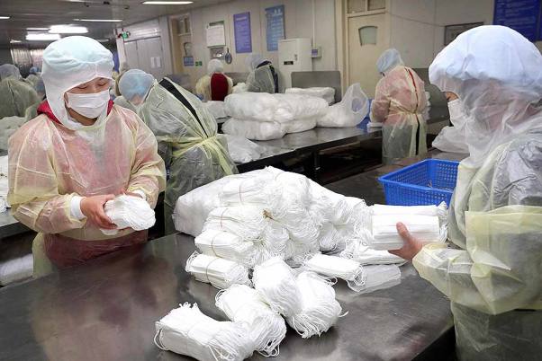 पूर्वी चीन के जिआंगसु प्रांत के नान्चॉन्ग की एक फैक्ट्री में मेडिकल मास्क पैक करते श्रमिक