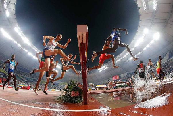 कतर में विश्व एथलेटिक्स चैंपियनशिप में पुरुषों की 3000 मीटर की स्टीपलचेज हीट में प्रतिस्पर्धा करते धावक