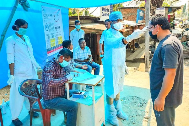 असम के बक्सा जिले में कोरोना वायरस के प्रकोप के मद्देनजर भारत-भूटान सीमा के पास रहने वाले निवासियों की थर्मल स्क्रीनिंग करता डॉक्टरों का एक समूह