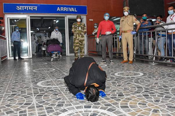 लखनऊ के चौधरी चरण सिंह अंतर्राष्ट्रीय हवाई अड्डे पर शारजाह से लौटने के बाद जमीन को चूमता एक यात्री
