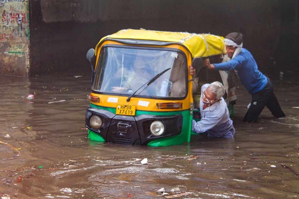फरीदाबाद में भारी बारिश के बाद अंडरपास में बाढ़ के पानी में फंसा एक ऑटो-रिक्शा