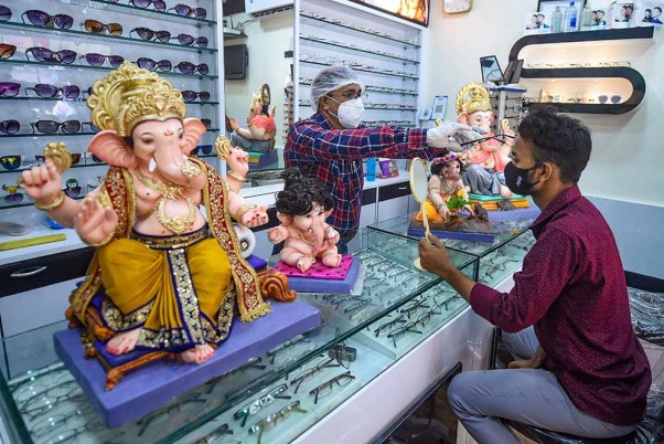 मुंबई: कोविड-19 महामारी के दौरान गणेश चतुर्थी से पहले अपनी दुकान पर चश्में के साथ गणपति की मूर्तियां भी बेचता एक ऑप्टिशियन