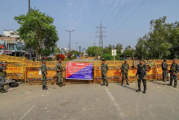 नई दिल्ली के शाहीन बाग में एक बैरिकेड के पास पहरा देते सुरक्षाकर्मी