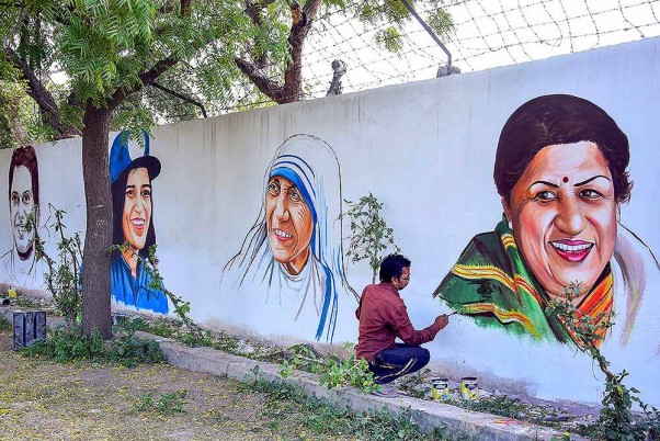 बीकानेर में 'बेटी बचाओ बेटी पढाओ' अभियान के तहत दिग्गज महिलाओं के चित्रों को दीवार में उतारता एक कलाकार