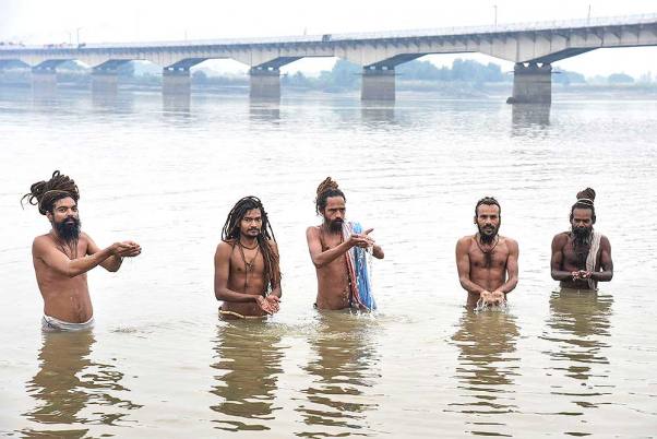 अयोध्या में सरयू नदी पर सूर्य देवता की प्रार्थना करते संत