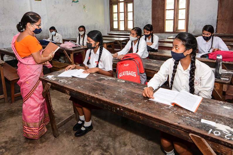 असम में स्कूलों को फिर से खोलने की अनुमति के बाद कक्षा में वापस लौटे छात्रा