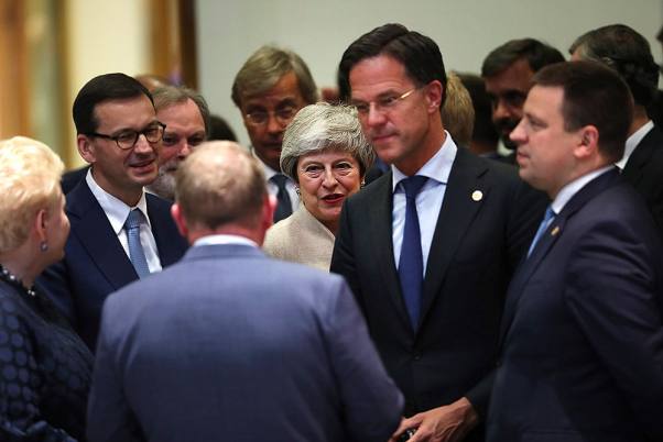 ब्रुसेल्स में यूरोपीय संघ के शिखर सम्मेलन में डिनर मीटिंग के दौरान अन्य यूरोपीय संघ के नेताओं के बीच खड़ी ब्रिटिश प्रधानमंत्री थेरेसा मे