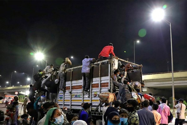 गाजियाबाद में लॉकडाउन के दौरान यूपी- दिल्ली बॉर्डर पर एक ट्रक में सवार होते प्रवासी मजदूर