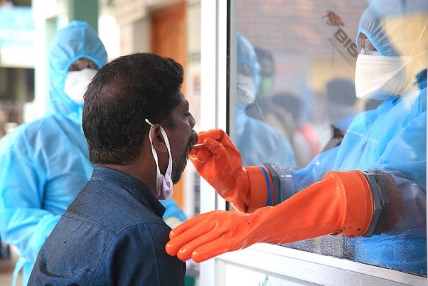 कोरोना वायरस महामारी के मद्देनजर कन्याकुमारी जिले में सब्जी विक्रेताओं का कोविड-19 टेस्ट करने के लिए सुरक्षात्मक सूट पहनकर स्वाब के नमूने लेते स्वास्थ्यकर्मी