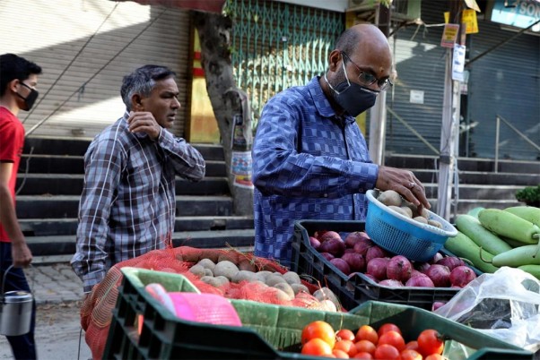 कोरोना वायरस महामारी के मद्देनजर 21 दिनों के राष्ट्रव्यापी बंद के दूसरे दिन गाजियाबाद में सब्जियां खरीदते लोग