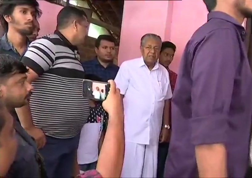 कन्नूर जिले के पिनाराई में मतदान केंद्र पर वोट डालने के लिए कतार में खड़े हुए केरल के सीएम पी. विजयन