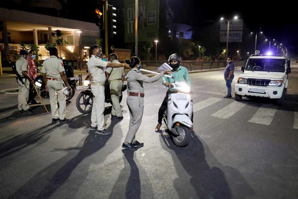 अहमदाबाद में नाइट कर्फ्यू के दौरान लोगों को रोकते पुलिसकर्मी