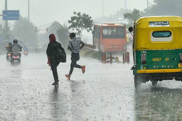 नई दिल्ली में कई स्थानों पर बारिश आज बारिश हुई। बारिश में भीगने से बचने के लिए भागते लोग।