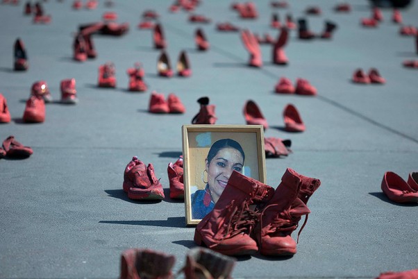 मैक्सिको सिटी के जोकोलो में महिलाओं के खिलाफ हिंसा का विरोध करने के लिए कार्यकर्ताओं द्वारा रखी गई लाल जूतों के बीच यूजेनिया मचुका कैम्पोस का चित्र