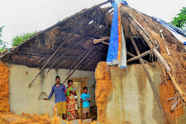पश्चिम मिदनापुर जिले के खड़गपुर में चक्रवात अम्फान के बाद अपने क्षतिग्रस्त घर के अंदर खड़ा एक परिवार