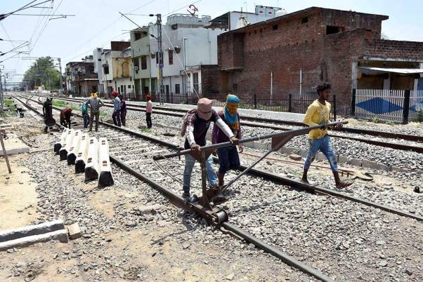 कोरोना वायरस के चलते लगाए गए लॉकडाउन के बीच अमेठी में रेलवे ट्रैक पर काम करते मजदूर