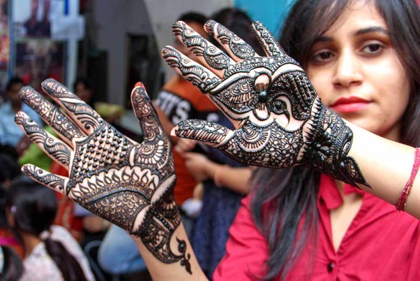 जम्मू में करवा चौथ त्योहार के मौके पर मेहंदी से सजी अपने हाथों को दिखाती एक महिला
