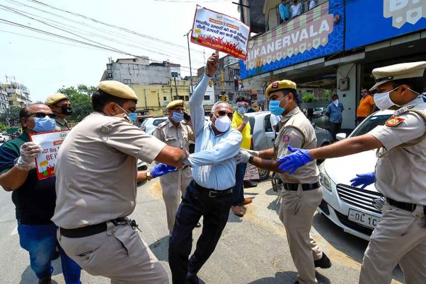 लद्दाख में चीन के साथ झड़प में भारतीय जवानों की शहादत पर दिल्ली की सड़कों पर उतरे अखिल भारतीय व्यापारी परिसंघ (कैट) के एक कार्यकर्ता को हिरासत में लेते पुलिसकर्मी
