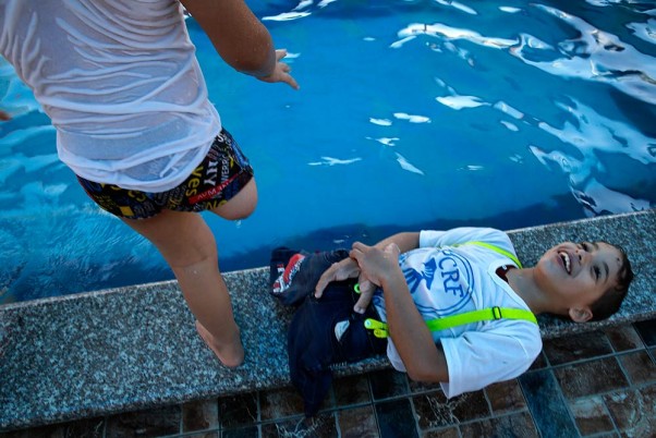 दक्षिणी गाजा पट्टी के खान यूनिस में समर कैंप के दौरान एक स्विमिंग पूल में खेलते अपना अंग खो चुके फिलिस्तीनी बच्चे