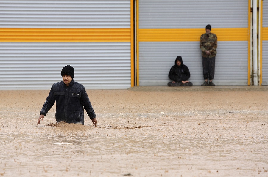 ईरान पिछले दो हफ्तों से बड़ी बाढ़ का सामना कर रहा है। पश्चिमी प्रांत लोरेस्टन के खोरमाबाद शहर में एक व्यक्ति बाढ़ वाली सड़क को पार करता हुआ।