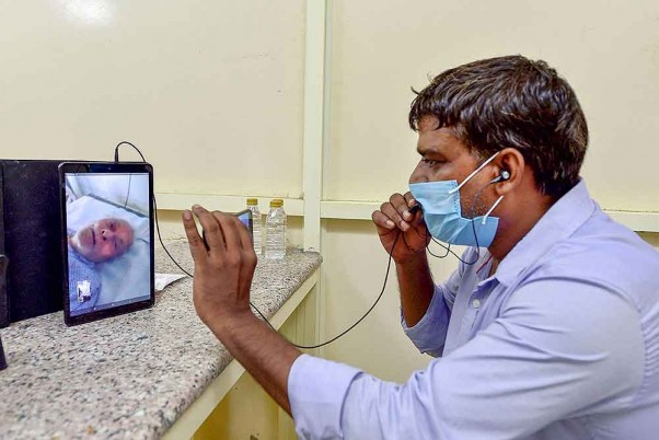 नई दिल्ली के एलएनजेपी अस्पताल में हेल्प डेस्क द्वारा आयोजित वीडियो कॉलिंग के माध्यम से एक कोविड-19 मरीज के साथ बातचीत करता उसका रिश्तेदार