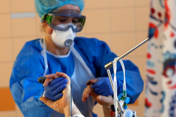चेक गणराज्य की राजधानी प्राग में स्थित जनरल यूनिवर्सिटी अस्पताल के आईसीयू में कोविड-19 के मरीज का इलाज करती स्वास्थ्यकर्मी