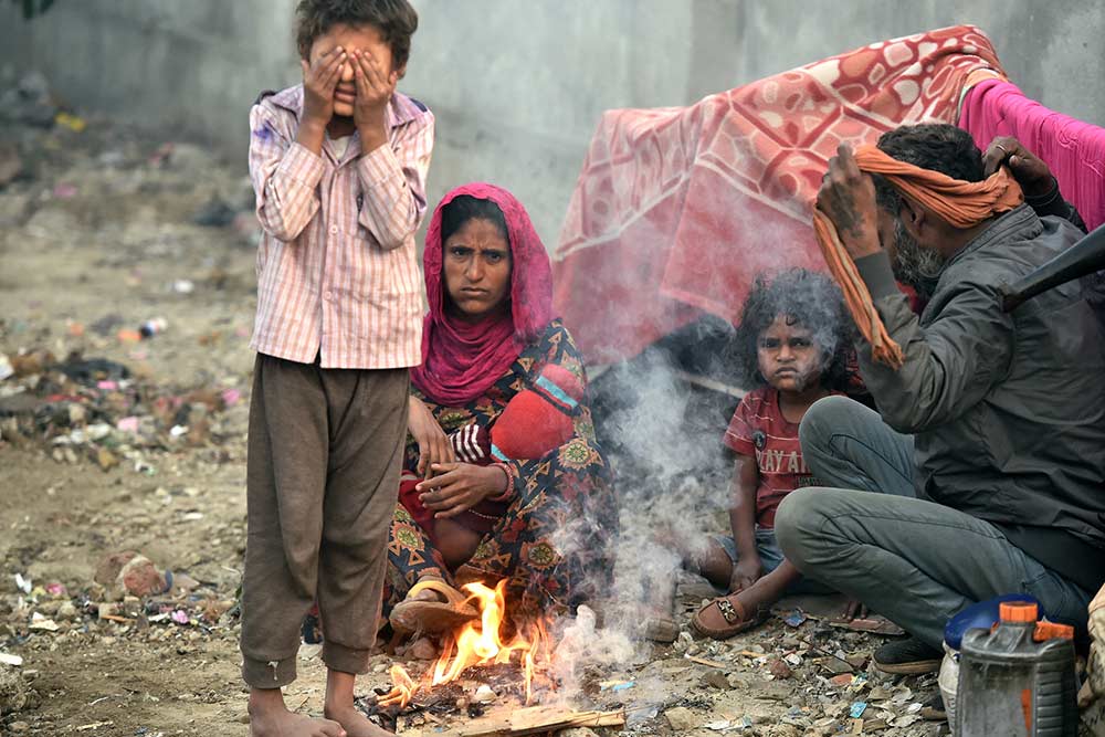 दिल्ली में सर्दी के सितम से राहत पाने के लिए आग का सहारा लेते लोग