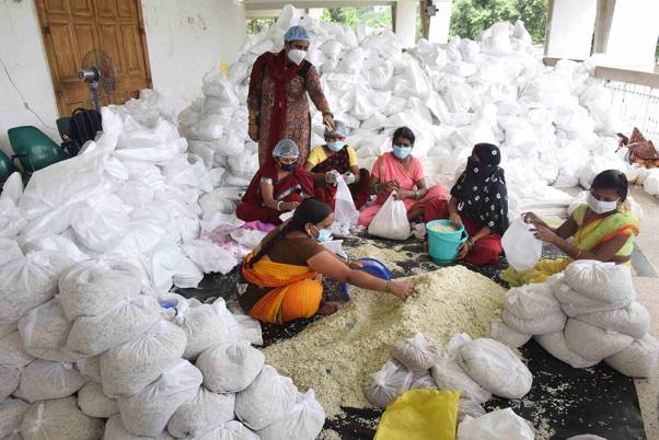 पटना के एसकेएम हॉल में बाढ़ प्रभावित लोगों के लिए भोजन का पैकेट तैयार करते वालंटियर