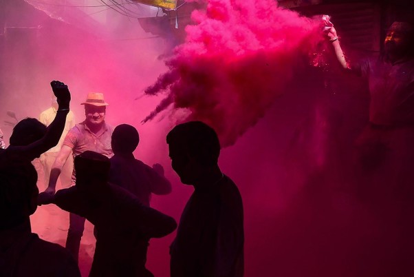 नई दिल्ली में सूखे रंगों से होली खेलते लोग