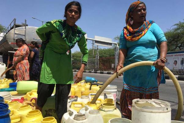 राजधानी दिल्ली में टैंकर से पीने का पानी लेने के लिए कतार में खड़ी महिलाएं