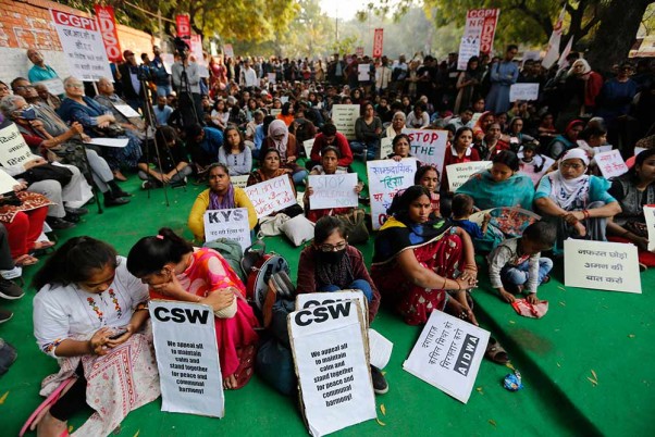 नई दिल्ली में हिंसा के बाद तख्तियां लिए शांति और सांप्रदायिक सद्भाव का आह्वान करते विभिन्न संगठनों के कार्यकर्ता
