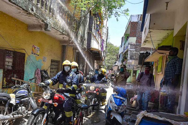 चेन्नई में लॉकडाउन के पांचवें चरण के दौरान मोटरसाइकिल से एक कंटेनमेंट जोन में कीटाणुनाशक का छिड़काव करते कर्मचारी
