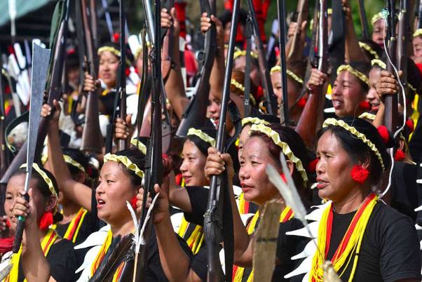 कोहिमा के किसामा में आयोजित वार्षिक हॉर्नबिल उत्सव के दूसरे दिन अपनी बंदूकों के साथ प्रदर्शन करते कोन्याक जनजाति के लोग