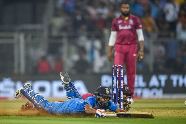 मुंबई के वानखेड़े स्टेडियम में वेस्टइंडीज के खिलाफ तीसरे टी 20 क्रिकेट मैच के दौरान रन पूरा करते रोहित शर्मा