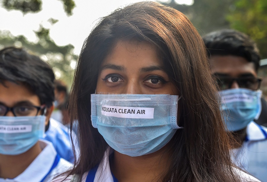कोलकाता में वायु प्रदूषण के खिलाफ जागरुकता के लिए मास्क पहनकर मार्च निकालते लोग