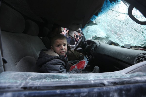 सीरिया के इदलिब प्रांत के अरिहा शहर में हवाई हमले के बाद एक गाड़ी में रोता बच्चा