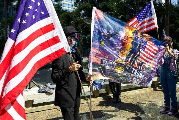 हांगकांग में एक रैली के दौरान अमेरिकी झंडे के साथ प्रदर्शनकारी