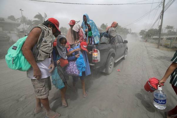 फिलिपींस की राजधानी मनीला के नजदीक ज्वालामुखी के सक्रिय होने की वजह से सुरक्षित स्थान पर जाता एक परिवार