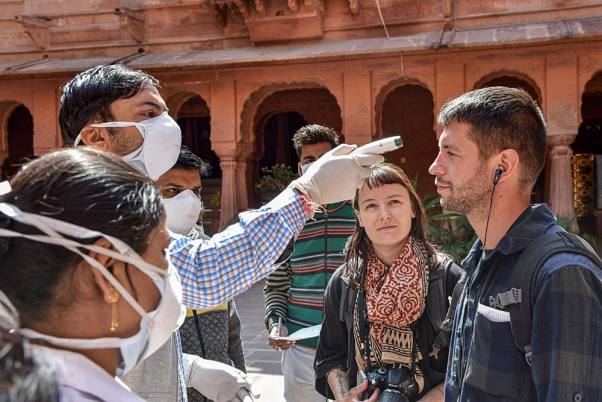 बीकानेर के जूनागढ़ किले में कोरोना वायरस को लेकर एक पर्यटक की थर्मल स्क्रीनिंग करते हुए