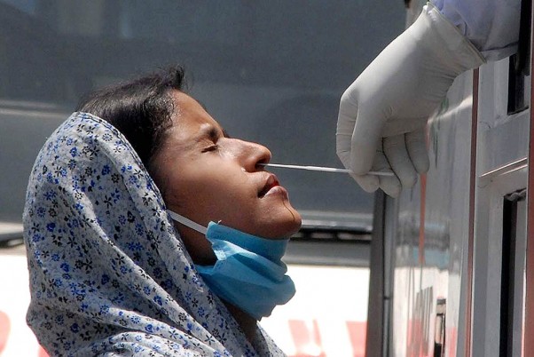 लॉकडाउन के दौरान नोएडा के सेक्टर-30 में जिला अस्पताल में कोविड-19 टेस्ट के लिए एक महिला का स्वाब सैंपल लेते स्वास्थ्यकर्मी