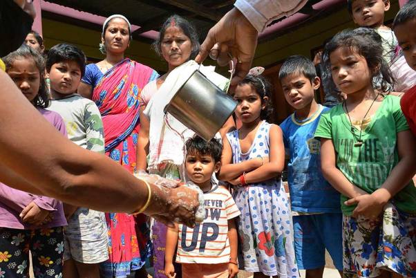 बक्सा जिले के उत्तरपारा गांव में कोरोना वायरस के मद्देनजर ग्रामीणों को 'हाथ धोने' का तरीका बताते वालंटियर