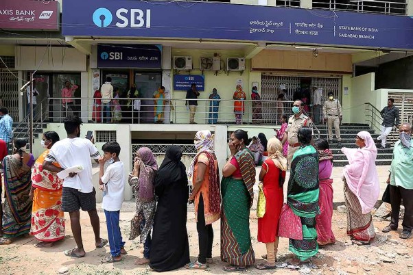 लॉकडाउन के दौरान सरकार द्वारा खातों में डाली गई राहत राशि को निकालने के लिए हैदराबाद में एक बैंक के बाहर कतार में खड़े लोग