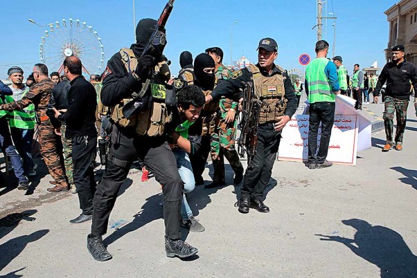 इराक के बसरा में एक प्रदर्शनकारी को गिरफ्तार कर ले जाते सुरक्षाकर्मी।