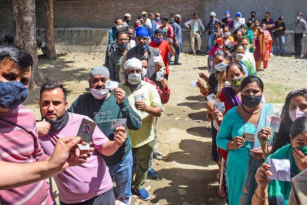 हिमाचल के मंडी में नगर निगम चुनावों में  वोट डालने के लिए लगी पोलिंग बूथ पर लोगों की कतार