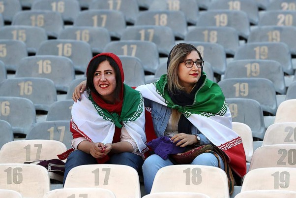 तेहरान में ईरान और कंबोडिया के बीच 2022 विश्व कप क्वालीफायर फुटबॉल मैच के लिए आजादी स्टेडियम में अपने कंधों पर अपने देश का झंडा लहराती ईरानी महिलाएं