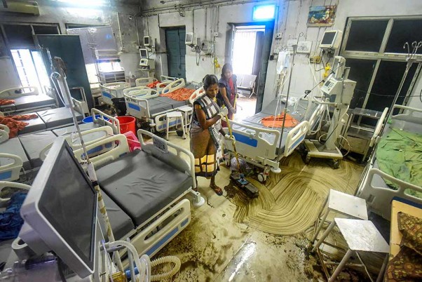 पटना में बाढ़ प्रभावित नालंदा मेडिकल कॉलेज और अस्पताल की गहन चिकित्सा इकाई (आईसीयू) में फर्श की सफाई करती कर्मचारी